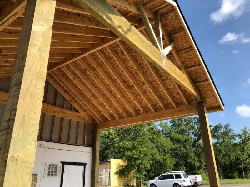 A new custom build carport with high pitched and shingled roof.